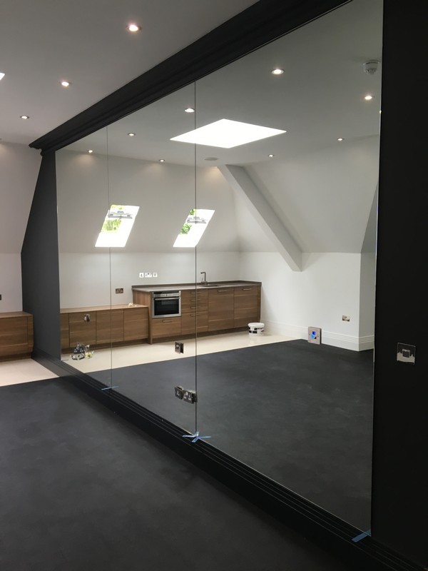 Frameless glass partition in loft conversion by Lewisham glaziers