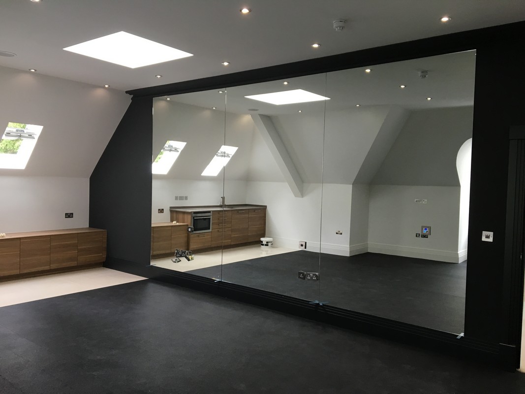 Frameless glass wall dividing loft conversion in Lewisham